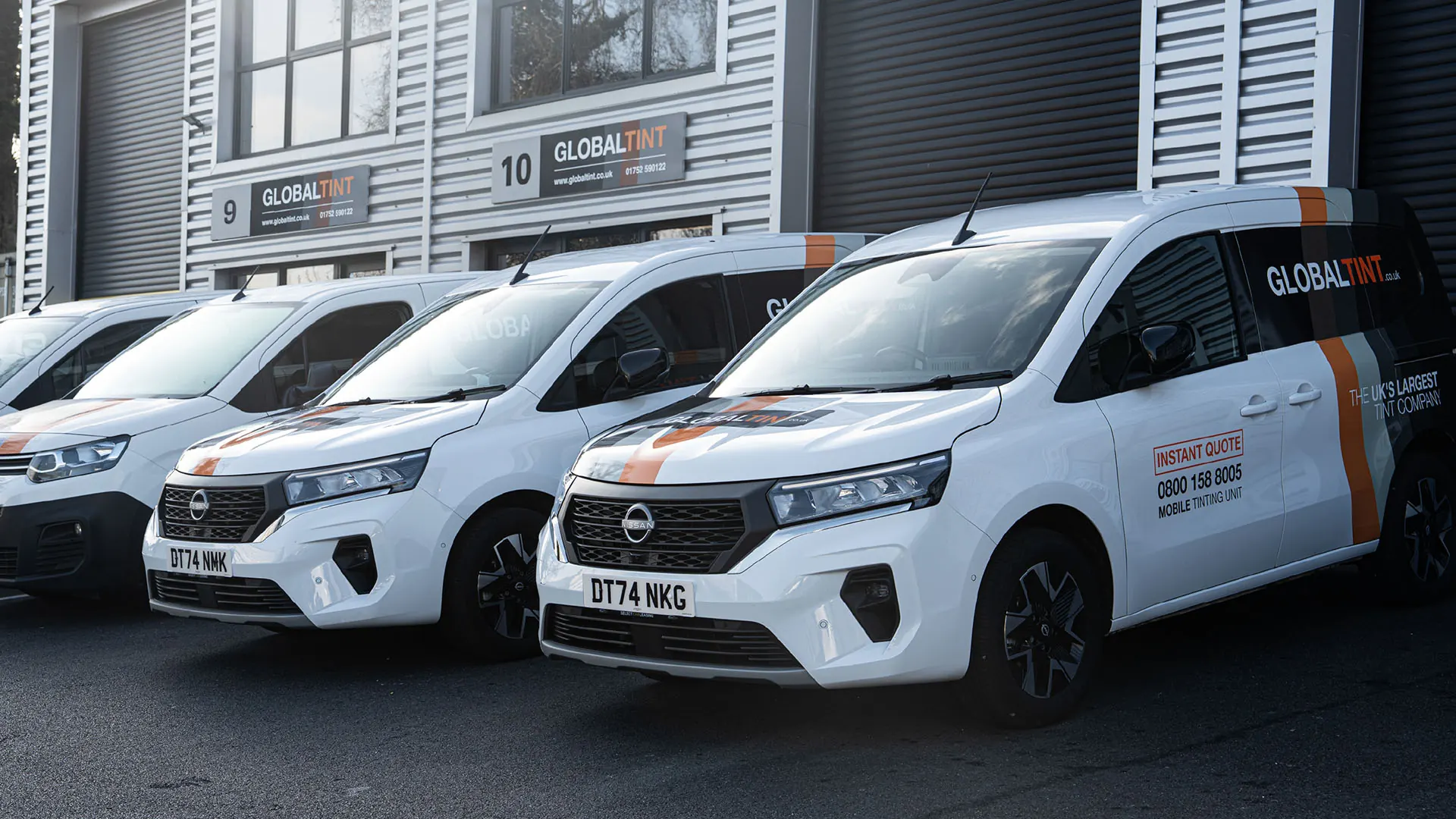 Global Tint's branded vans parked outside the Global Tint units