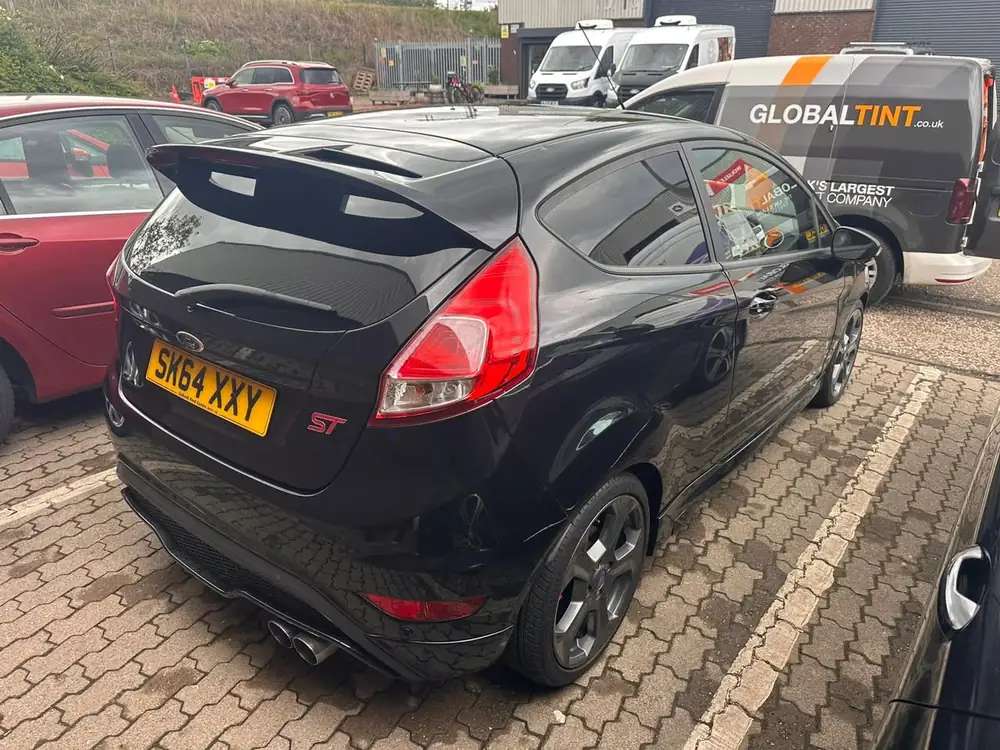Black Ford Fiesta ST viewed from the rear, with a dark-tinted rear side window and back windscreen