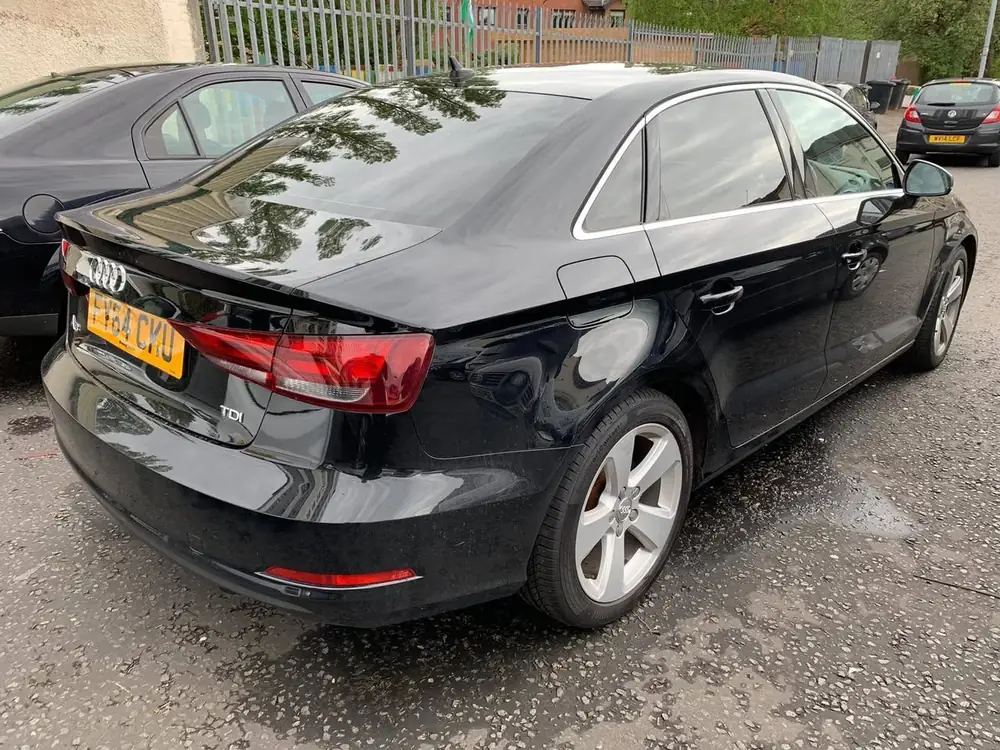 Black saloon with dark rear windows, viewed from the rear beside another parked car
