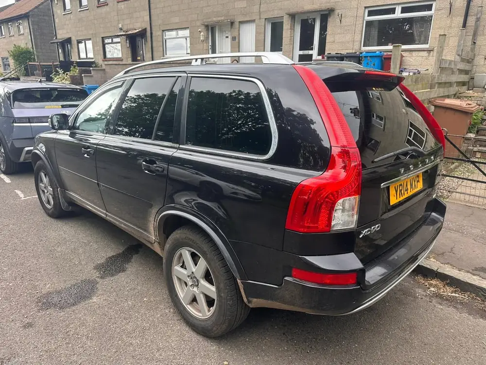 Black Volvo XC90 viewed from the rear, with dark rear side windows and rear windscreen