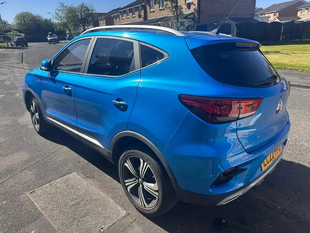 Blue MG ZS viewed from the rear, with dark rear side glass and rear windscreen