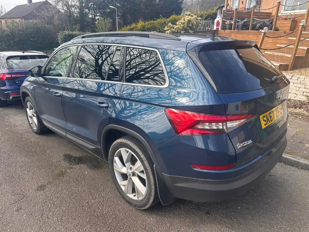 Blue Skoda Kodiaq with dark rear side windows and rear windscreen, parked on tarmac.
