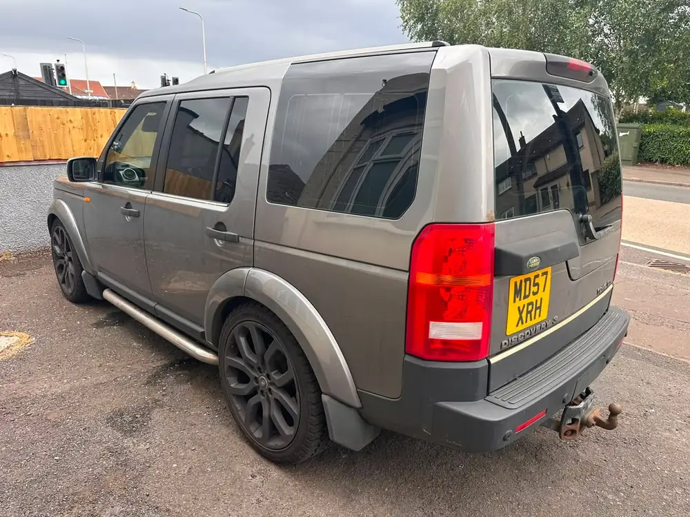 Grey Land Rover Discovery 3 viewed from behind, with dark tinted rear side windows and rear windscreen.