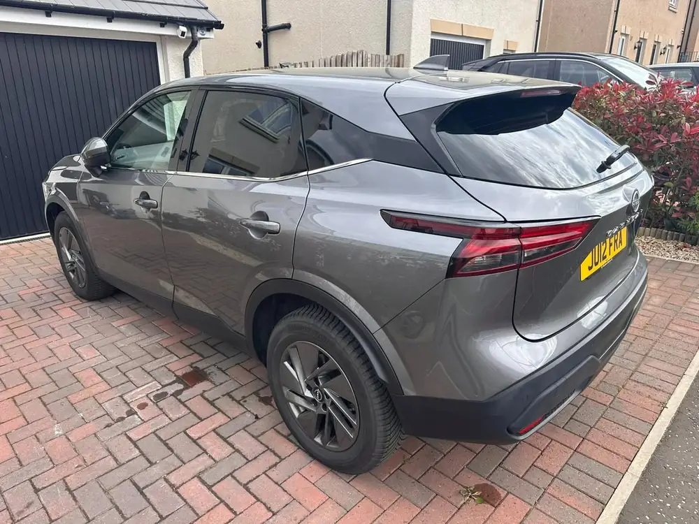 Grey Nissan Qashqai with dark rear side windows and rear windscreen, parked on a brick driveway.