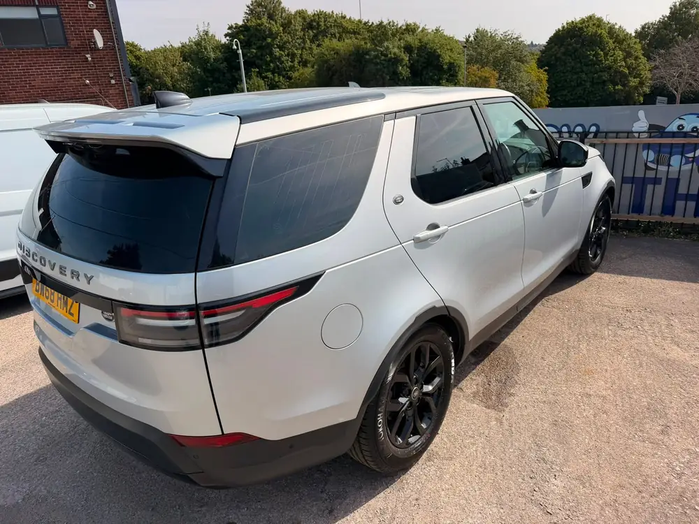 Light grey Land Rover Discovery with dark rear side windows, rear windscreen and black wheels