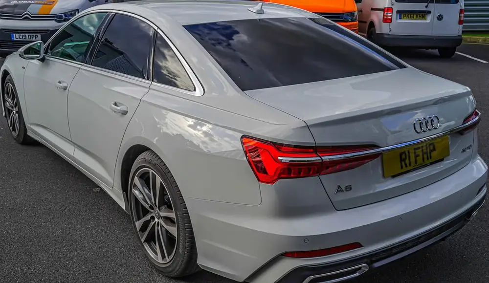 Silver Audi A6 saloon with dark rear side windows and rear windscreen, viewed from behind