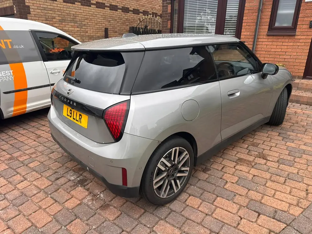Silver MINI Cooper with dark rear side glass and back windscreen, parked on a brick driveway.