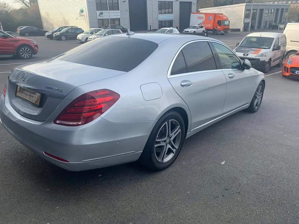 Silver saloon with dark rear side windows and rear windscreen, viewed from a rear corner