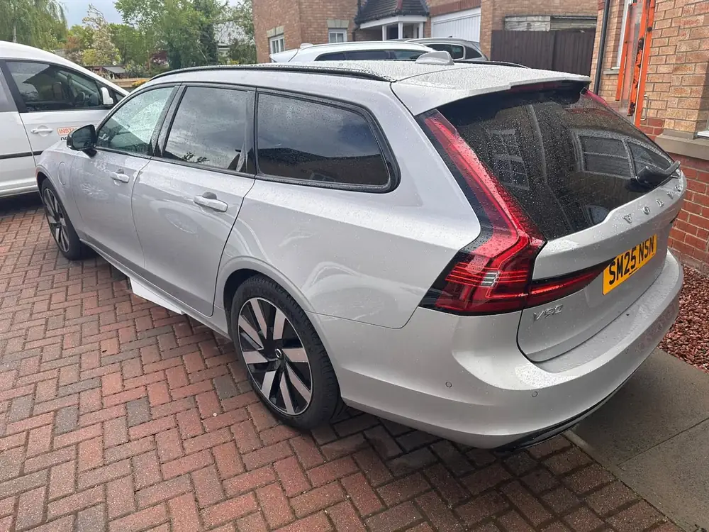 Silver Volvo V90 with dark rear side windows and rear windscreen, parked on a paved driveway.