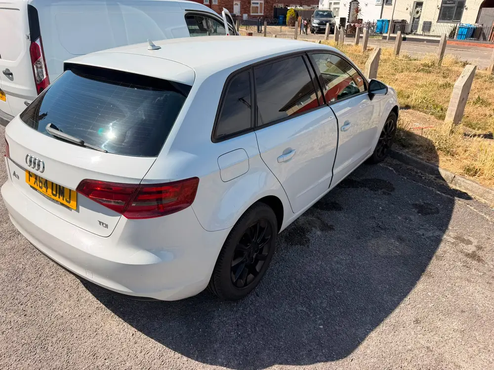White Audi A3 Sportback with dark rear side windows and rear windscreen, parked beside a white van