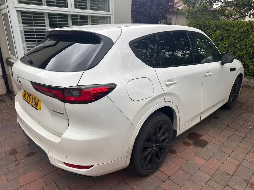 White Mazda CX-60 with tinted rear side windows and back windscreen, parked on a paved driveway