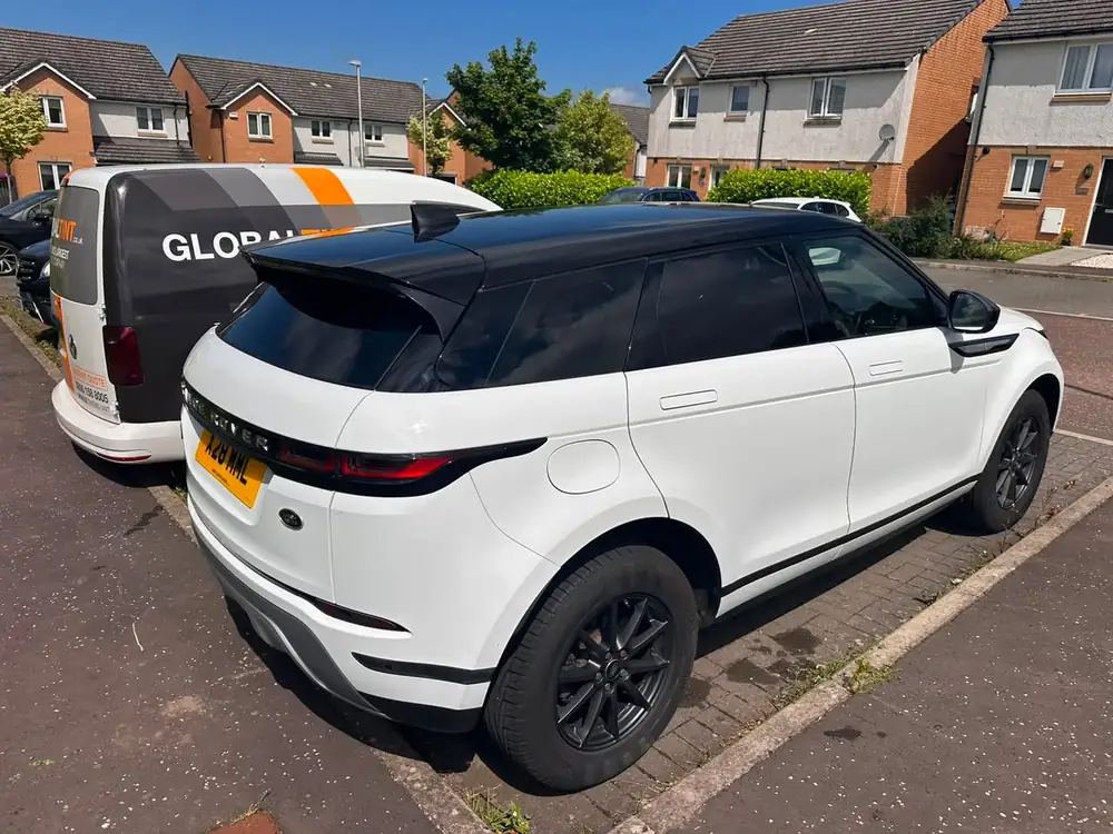 White Range Rover Evoque with a black roof, dark tinted rear side windows and rear windscreen