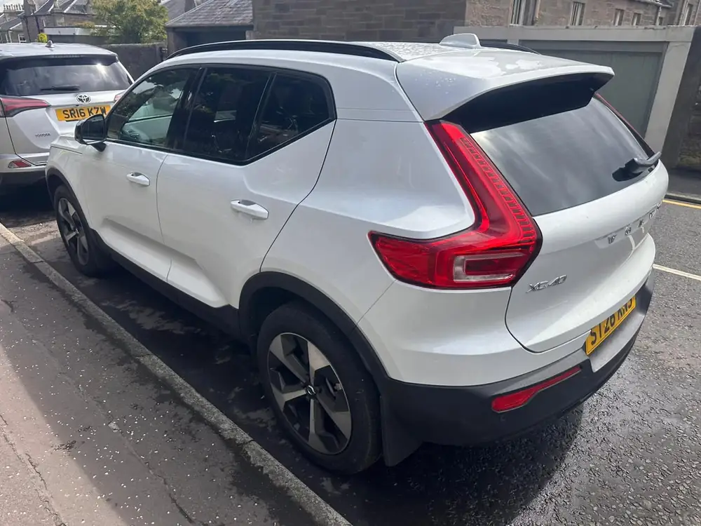 White Volvo XC40 viewed from the rear, with dark tinted rear side glass and back windscreen.